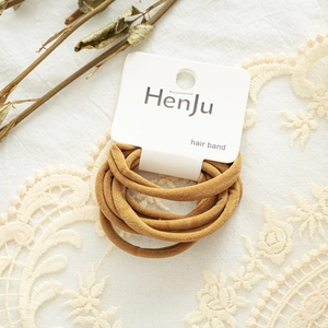 Close-up of brown velvet hair bands set on a display card with delicate lace backdrop