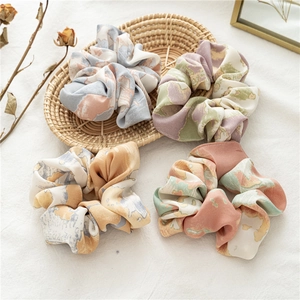 Vue détaillée des chouchous en satin dégradé avec motifs marbrés et texture soyeuse