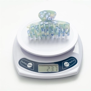 Detailed weight measurement showing 23.7g for the light blue tortoise shell hair claw clip