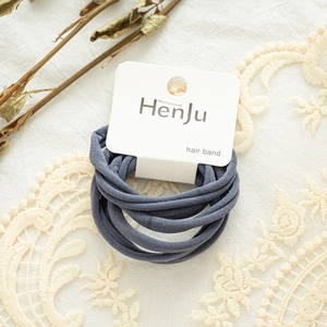Deep blue elastic hair bands set on a display card over a delicate white lace background