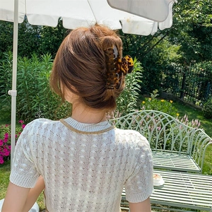 Detail of 10cm leopard print acetate hair claw clip securely holding a French twist hairstyle