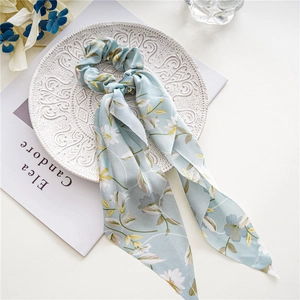 Detail eines hellblauen Satin-Haargummis mit Blumenmuster und langen Bändern