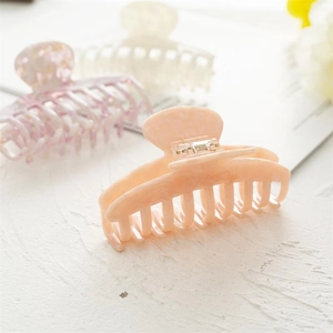 Detail view of large acetate hair claws with multi-tooth design and durable springs