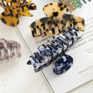 Detailed view of large 10cm leopard and marble acetate hair claws for french bun styling