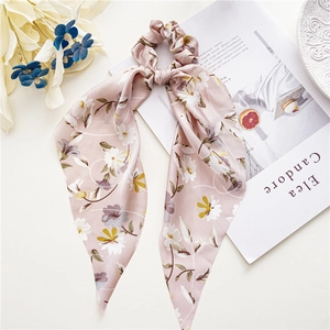 Detailaufnahme des rosa Satin-Haargummis mit floralem Muster und elegantem Faltenwurf