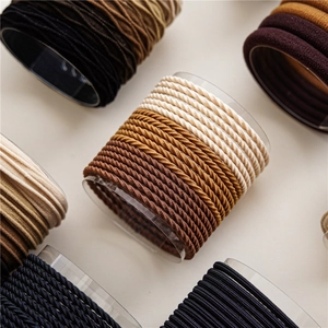 Detail of high-elasticity hair ties in earth tones on transparent cylindrical display
