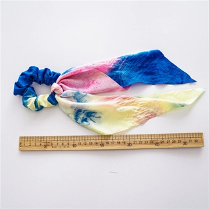 Vue détaillée du chouchou en tissu tie-dye avec de longs rubans et une règle