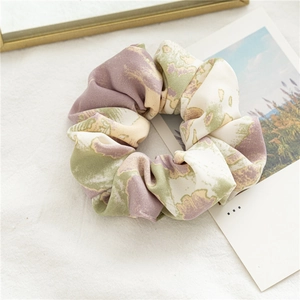 Détail d'un chouchou en satin fleuri avec des motifs aquarelle pastel doux