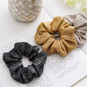 Vue détaillée des chouchous en tissu plissé élastique en noir, jaune et argent brillant