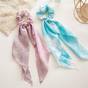 Détail de chouchous en mousseline à dégradé rose et bleu avec de longs rubans