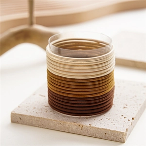 Detailed close-up of seamless elastic hair ties in earth tones on a stone stand