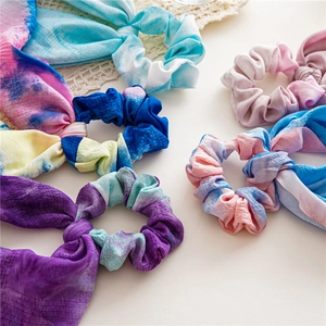 Détail de chouchous en tissu tie-dye avec de longs rubans et une texture gaufrée