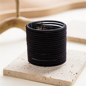 Stack of 50 black high-elastic seamless hair ties displayed on a transparent stand