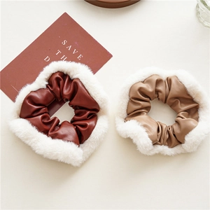 Close-up of contrast color PU leather scrunchies with white faux fur edges for winter