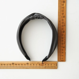Cerchietto largo in pelle PU grigio scuro con nodo e misura del diametro di 14 cm