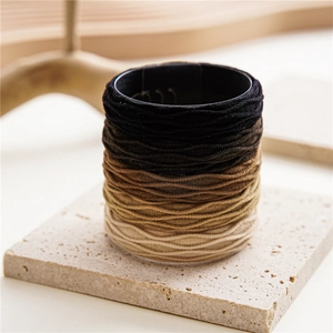 Detailed macro view of multi-color gradient hair ties on a sleek black display stand