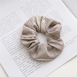 Gros plan d'un chouchou doré champagne métallisé avec texture plissée sur un livre