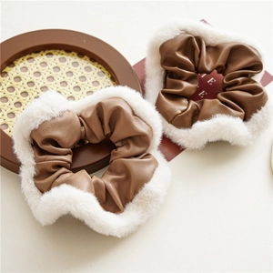 Close-up of brown PU leather scrunchies with white plush trim in a two-piece winter set