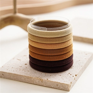 Close-up of high-elasticity seamless hair ties in a gradient of earth tones and beige