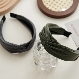 Cerchietti minimalisti in pelle PU intrecciata grigio scuro e verde oliva sul tavolo