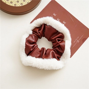 Detailed view of brown leather scrunchie with soft white faux fur trim for autumn