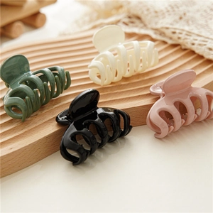 Detailed set of four matte resin shark hair clips in dark green, beige, black, and lotus pink