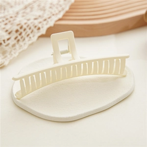 Detailed view of cream matte hair claw clip with large hollow design for thick hair