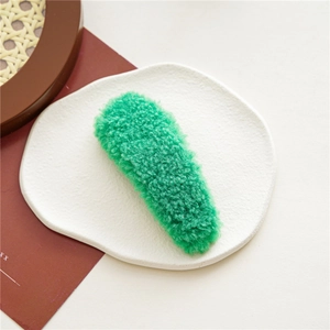 Détail d'une barrette à cheveux BB en peluche vert vif à texture douce effet peau d'agneau