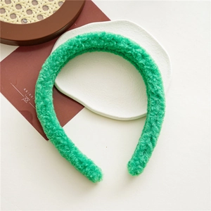 Vue de dessus du serre-tête en velours vert duveteux sur une assiette blanche style rétro