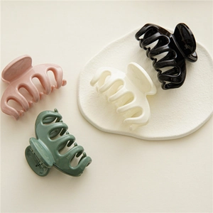 Polished resin hair claw clips in pink, white, black, and dark green for women