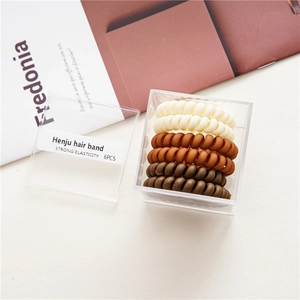 Detailed set of 6 matte spiral hair ties in earth tones with a clear storage box
