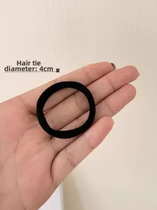 Detail showing high-elasticity black hair tie with 4cm diameter on neutral background