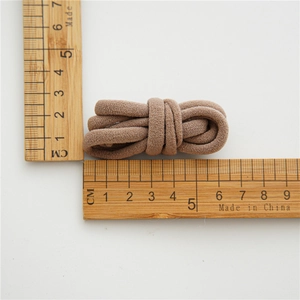 Close-up of high elasticity brown hair tie with 5.5cm measurement on white background