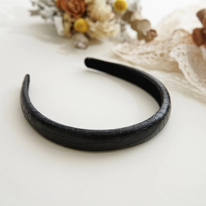 Detail showing black faux crocodile skin texture and thick sponge padding on headband