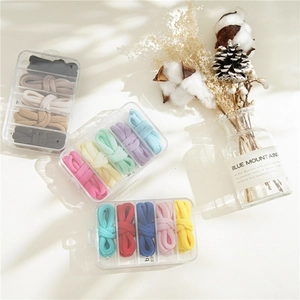 Three sets of thick elastic hair ties in a clear 5-grid storage box with candy colors