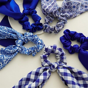 Detail of blue satin scrunchies set featuring floral and checkered patterns with ribbons