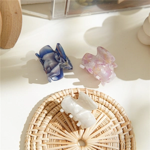 Gros plan de mini pinces à cheveux en acétate, couleurs marbre bleu, lavande et crème