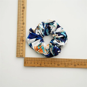 Détail d'un chouchou en coton tie-dye bleu et orange avec mesure de 10 cm de diamètre