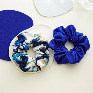 Détails de deux chouchous élastiques en bleu uni et aux motifs tie-dye artistiques