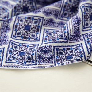 Detailed close-up of blue and white floral pattern satin fabric showing soft texture