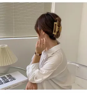 Détail d'une grande pince à cheveux rectangulaire jaune moutarde mat sur un mannequin