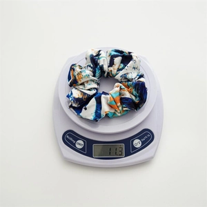 Gros plan d'un chouchou tie-dye bleu sur une balance pesant exactement 11,3 grammes