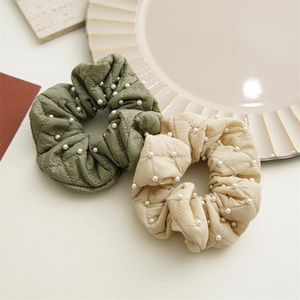Quilted fabric scrunchies in olive green and beige with white pearl accents
