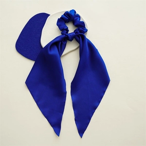 Detail of royal blue satin hair scrunchie with long ribbons and smooth silky texture