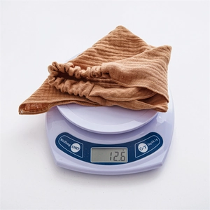 Detail shot of lightweight brown textured fabric headscarf weighing 12.6g on a digital scale