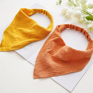 Close-up of yellow and red cotton gauze headbands with elastic band on white background