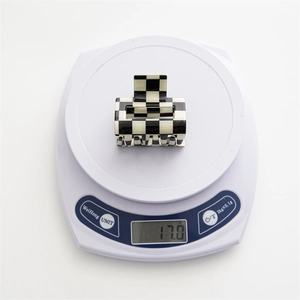 Weight measurement of black and white checkered square hair claw showing 17.0g