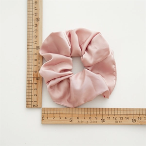 Macro shot of large pink satin scrunchie showing detailed 11cm diameter measurement