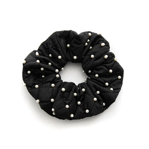 Elegant black quilted scrunchie with white pearl accents and soft padded texture