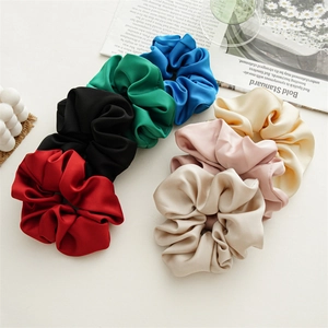Macro shot of colorful satin hair scrunchies with elegant silk-like texture in a set